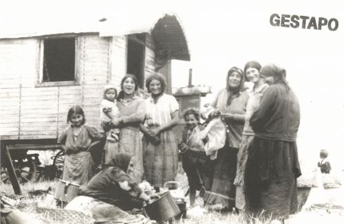 Women and children in front of a caravan