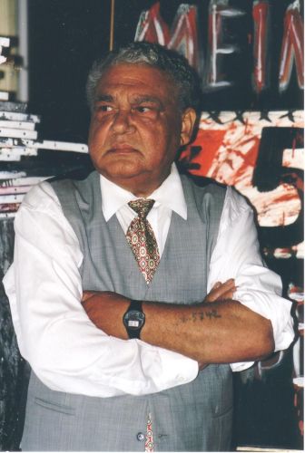Portrait photo of a standing man with folded arms