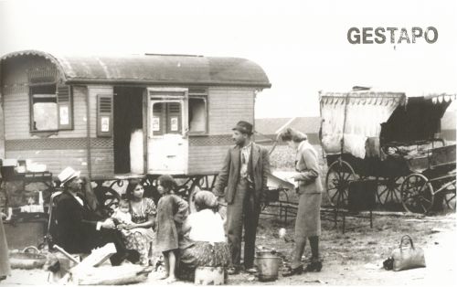 Roma family and woman in a uniform in front of a caravan